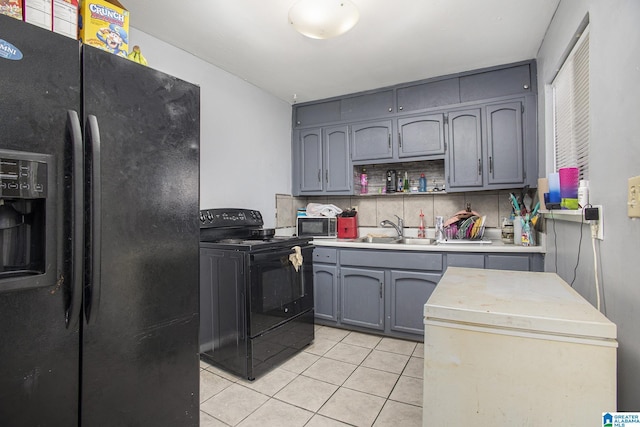 kitchen featuring light tile patterned floors, sink, backsplash, and black appliances