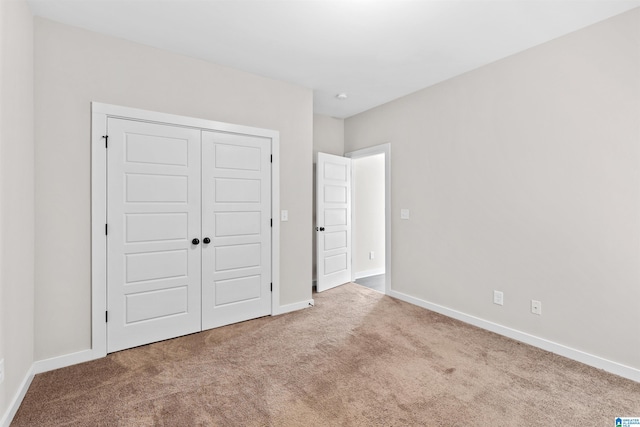 unfurnished bedroom with a closet and light carpet