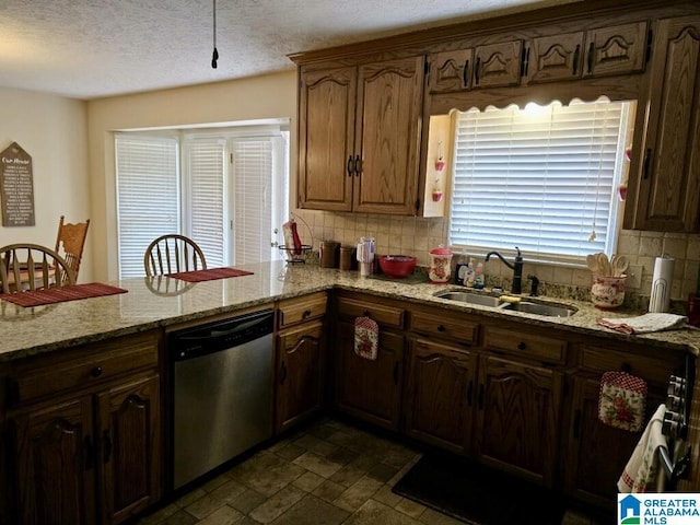 kitchen with stainless steel dishwasher, decorative backsplash, sink, a textured ceiling, and light stone counters