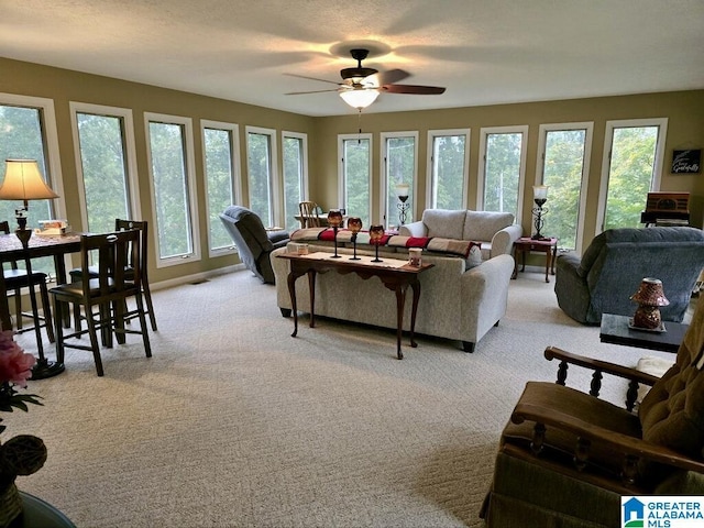 living room with ceiling fan, light colored carpet, and a textured ceiling