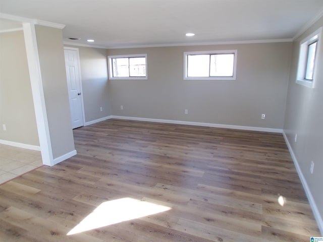 spare room featuring ornamental molding and light hardwood / wood-style flooring