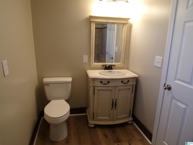 bathroom featuring hardwood / wood-style flooring, toilet, and vanity