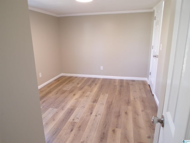 spare room featuring light hardwood / wood-style flooring and ornamental molding