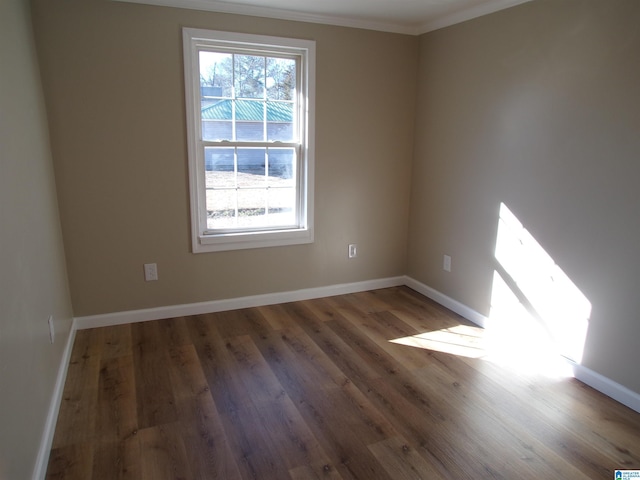 spare room featuring dark hardwood / wood-style flooring and ornamental molding