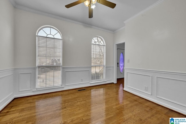 spare room with hardwood / wood-style flooring, crown molding, and ceiling fan