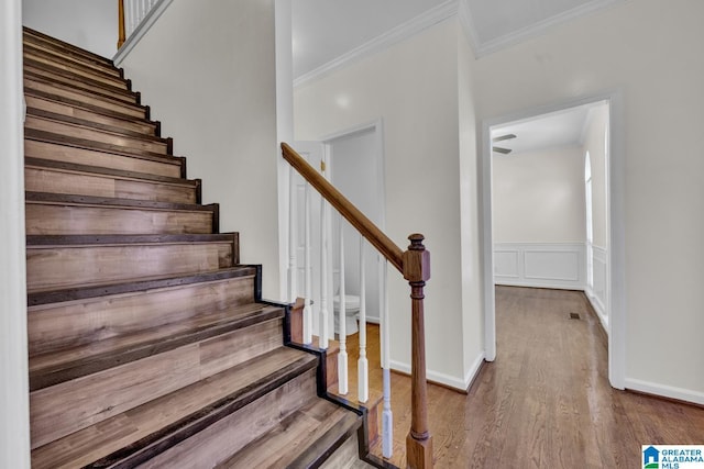 stairway featuring hardwood / wood-style floors and ornamental molding