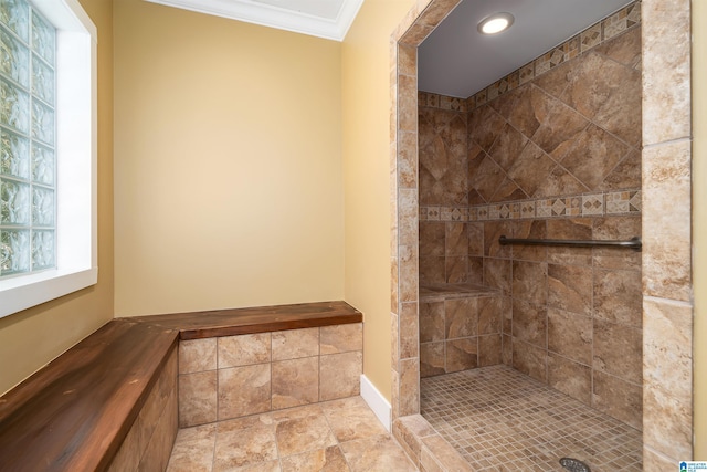 bathroom featuring ornamental molding and a tile shower