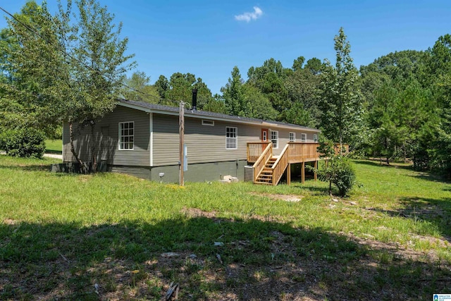 back of property featuring a wooden deck and a lawn