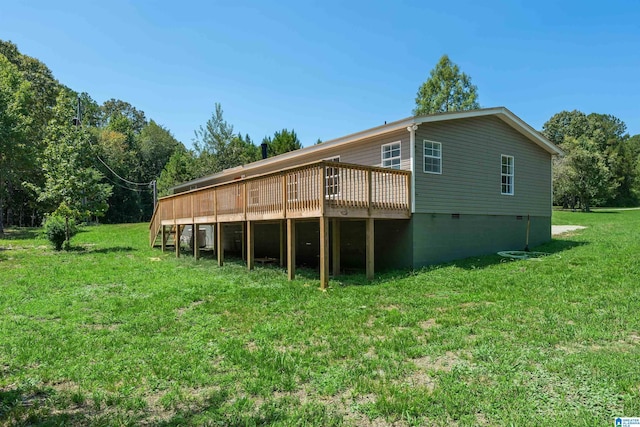 back of house with a wooden deck and a lawn