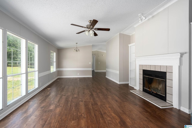 unfurnished living room with dark wood-type flooring, a textured ceiling, ornamental molding, and a fireplace