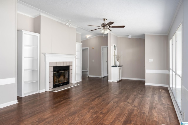 unfurnished living room featuring a textured ceiling, dark wood-type flooring, ornamental molding, and a fireplace