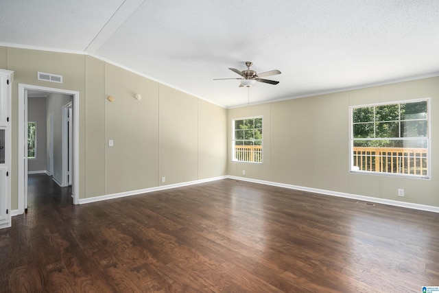 spare room with a textured ceiling, lofted ceiling, dark hardwood / wood-style flooring, ornamental molding, and ceiling fan