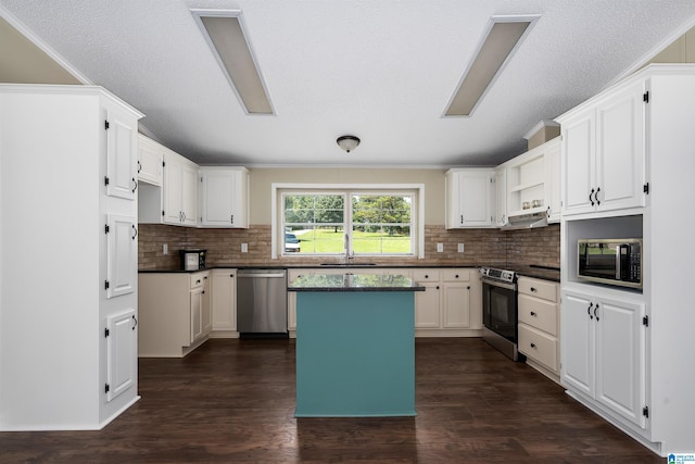 kitchen featuring a center island, decorative backsplash, appliances with stainless steel finishes, white cabinets, and dark hardwood / wood-style flooring