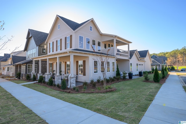 view of front of home featuring a balcony, covered porch, and a front yard