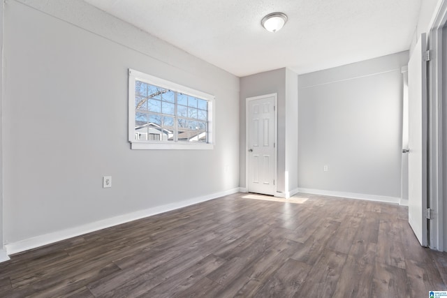 unfurnished bedroom with dark wood-type flooring and a textured ceiling