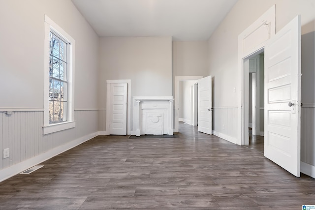 spare room featuring plenty of natural light and dark hardwood / wood-style flooring