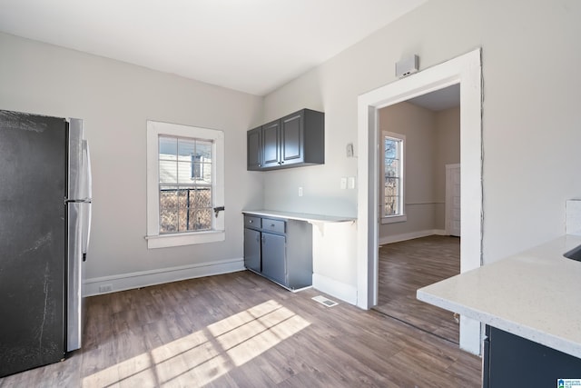 kitchen featuring gray cabinetry, light hardwood / wood-style flooring, and stainless steel refrigerator