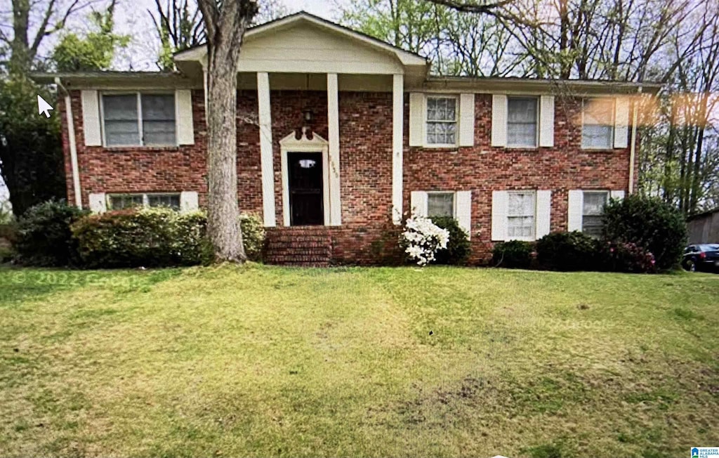 raised ranch featuring a front lawn