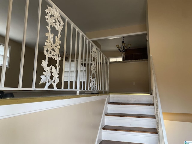 stairway featuring an inviting chandelier