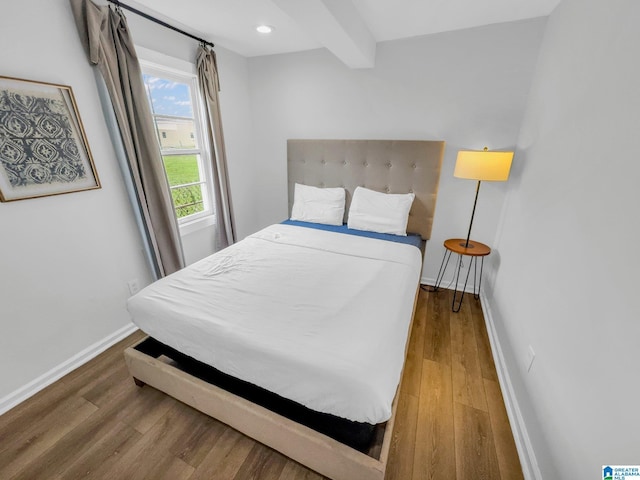 bedroom featuring beam ceiling and wood-type flooring