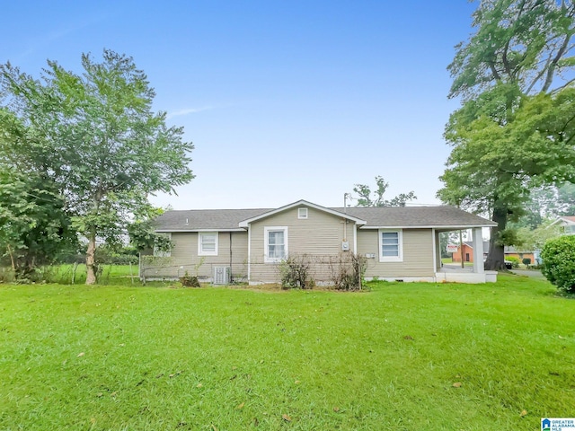 rear view of property featuring central AC and a yard