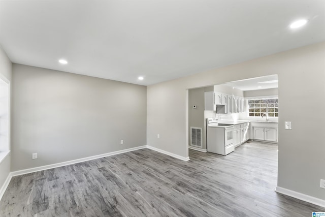 unfurnished living room featuring light hardwood / wood-style flooring and sink