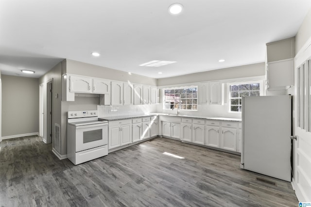 kitchen with dark wood-type flooring, white cabinetry, refrigerator, and electric stove