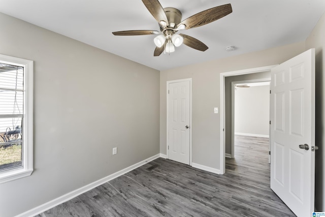 unfurnished bedroom with ceiling fan, a closet, and dark hardwood / wood-style floors