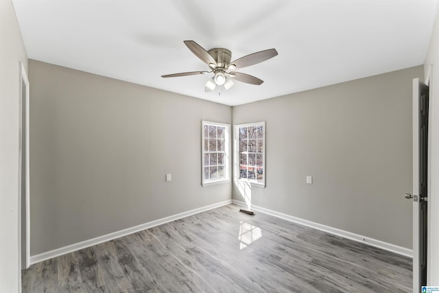 unfurnished room with ceiling fan and dark wood-type flooring