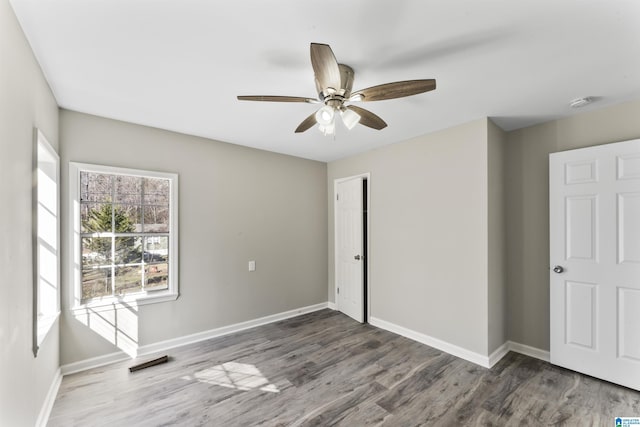 spare room featuring dark wood-type flooring and ceiling fan