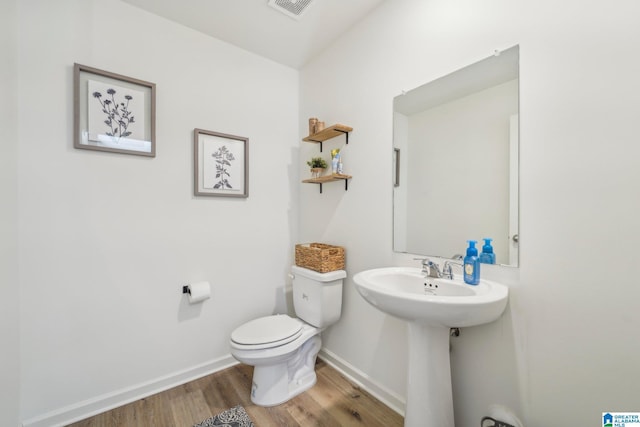 bathroom with wood-type flooring and toilet