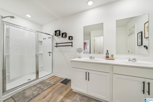 bathroom featuring hardwood / wood-style floors, a shower with shower door, and vanity