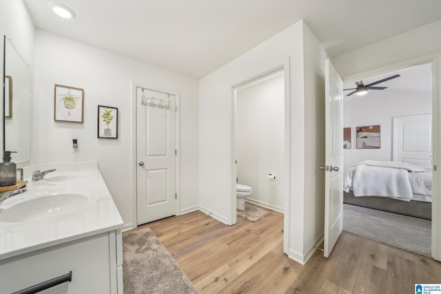 bathroom featuring hardwood / wood-style flooring, toilet, ceiling fan, and vanity