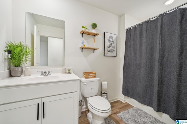 bathroom with wood-type flooring, toilet, and vanity