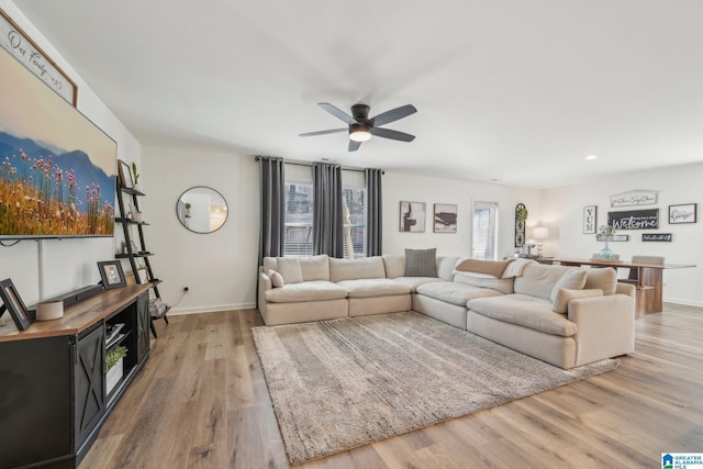 living room featuring light wood-type flooring and ceiling fan