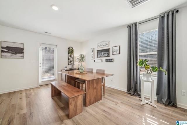 dining room with light hardwood / wood-style flooring and a wealth of natural light