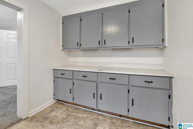 interior space featuring gray cabinetry and light colored carpet