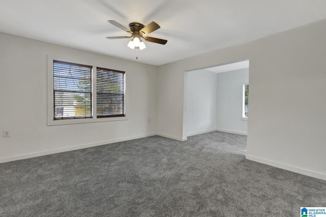 empty room featuring ceiling fan and dark carpet