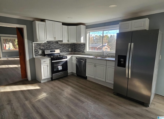 kitchen with dark wood-type flooring, appliances with stainless steel finishes, white cabinets, and sink