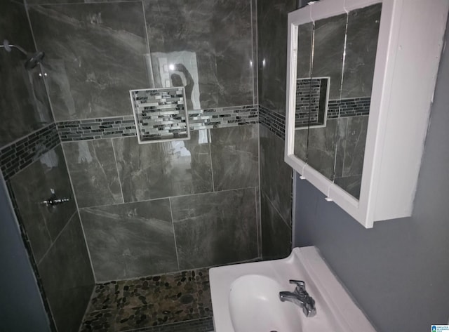 bathroom featuring sink and tiled shower