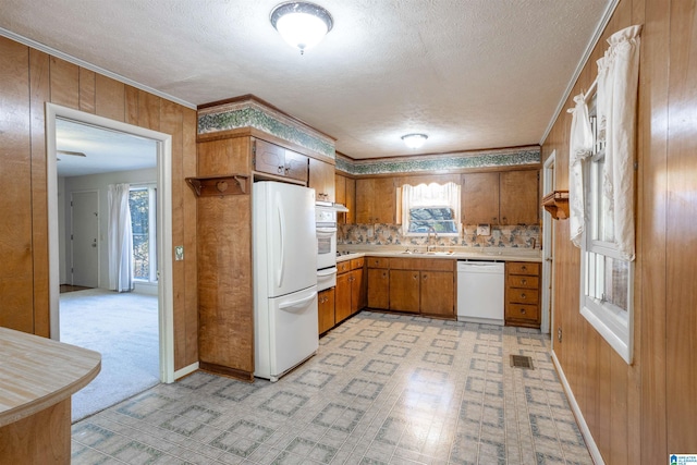 kitchen with crown molding, sink, white appliances, and a textured ceiling