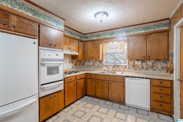 kitchen with a textured ceiling, crown molding, sink, and white appliances