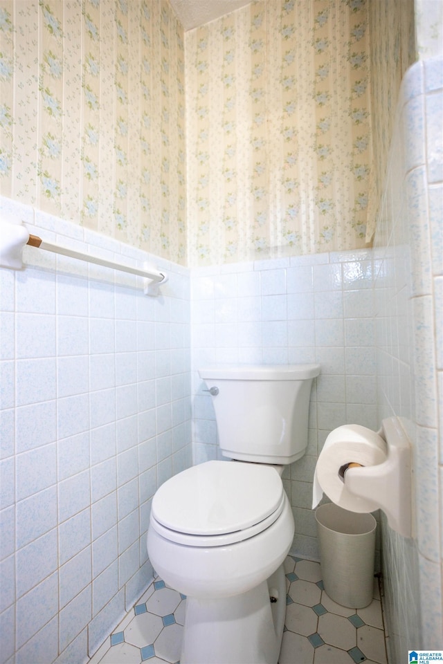 bathroom featuring toilet, tile walls, and tile patterned floors