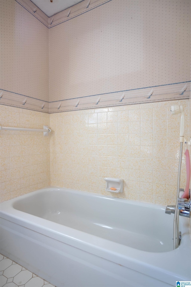 bathroom with a tub and tile patterned floors