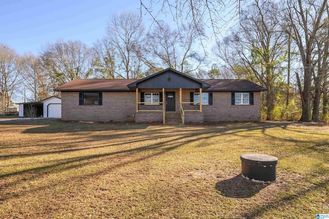 ranch-style house featuring a garage, a front lawn, a porch, and an outbuilding