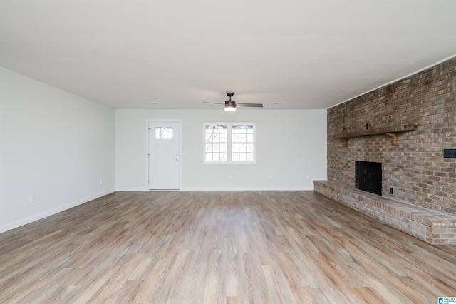 unfurnished living room featuring a fireplace, light hardwood / wood-style flooring, and ceiling fan