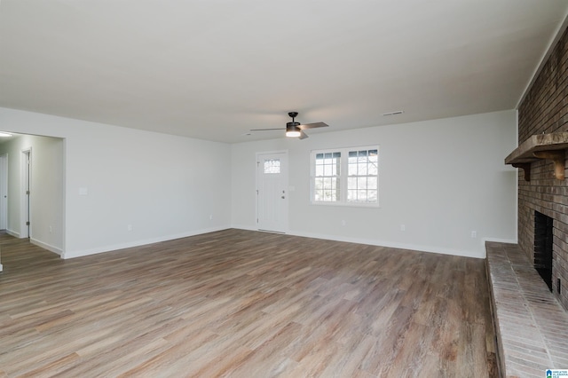 unfurnished living room with ceiling fan, light hardwood / wood-style flooring, and a fireplace