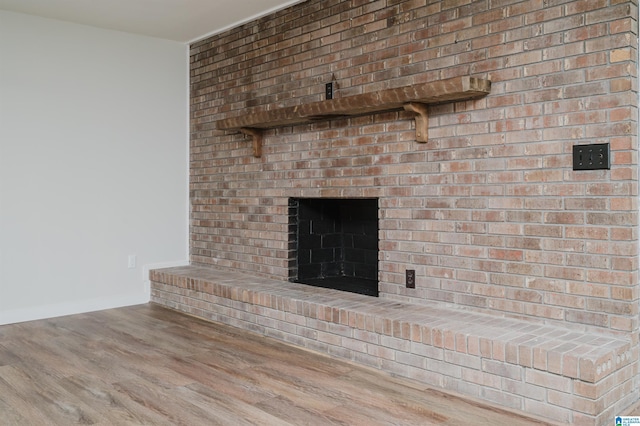 details with hardwood / wood-style flooring and a brick fireplace