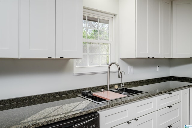 kitchen with sink, dark stone counters, white cabinetry, and dishwasher