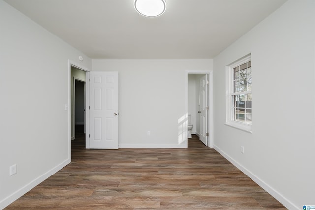 unfurnished bedroom with dark hardwood / wood-style flooring